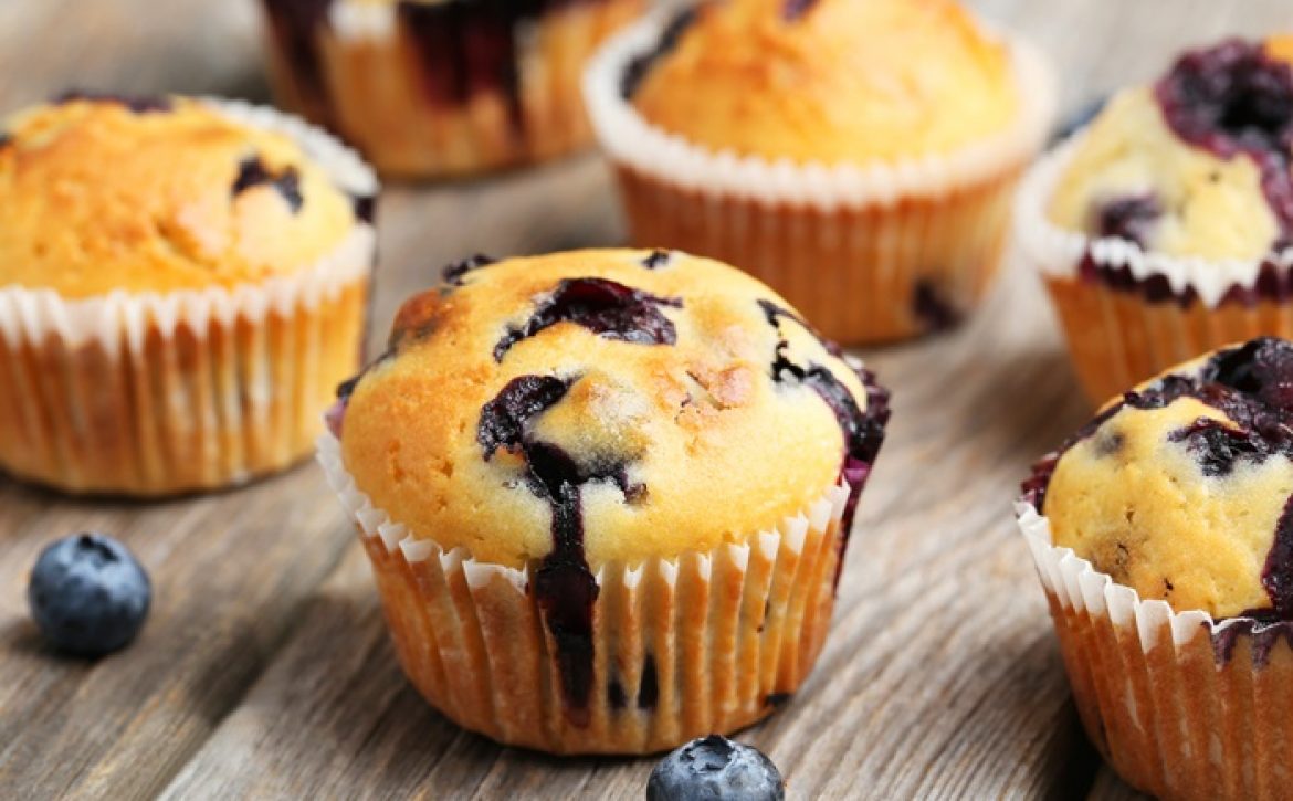 Tasty blueberry muffins on a grey wooden background