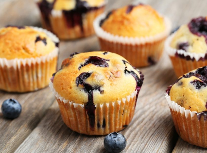 Tasty blueberry muffins on a grey wooden background